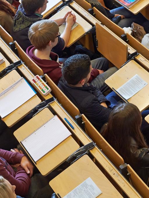 Studenten sitzen in einem Uni-Hörsaal bei der Erstsemesterbegrüßung