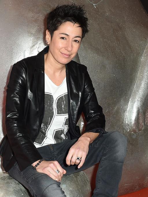 Die Moderatorin Dunja Hayali sitzt am 13.02.2015 in Berlin während der 65. Internationalen Filmfestspiele auf einer Skulptur.