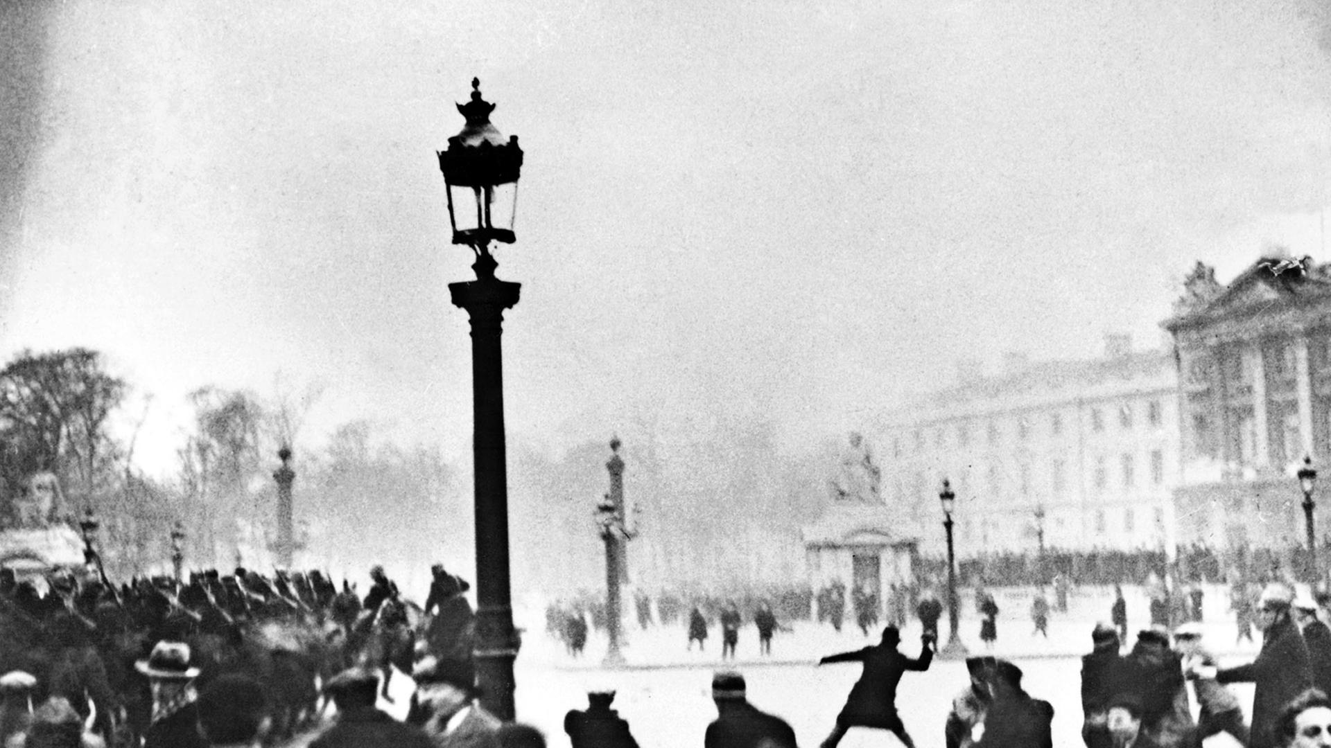 Die historische Schwarz-Weiß-Aufnahme zeigt Auseinandersetzungen auf einem Platz in Paris.