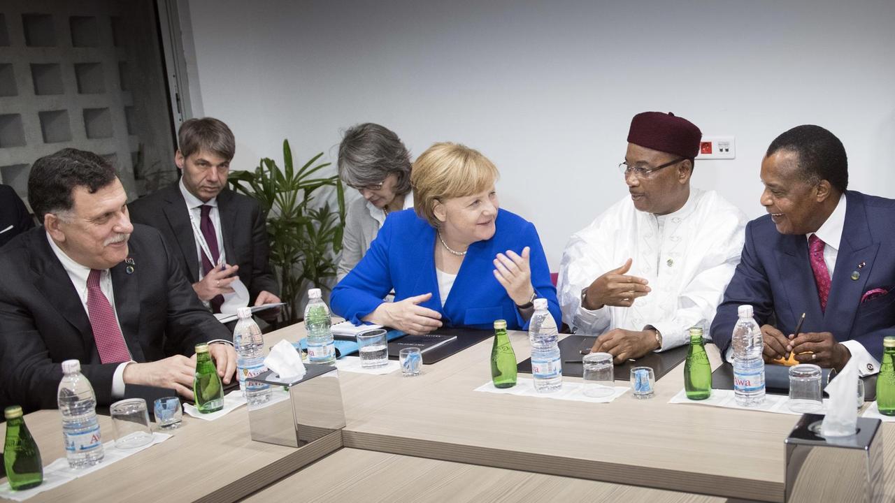 Das Handout der Bundesregierung zeigt Bundeskanzlerin Angela Merkel (CDU), den Präsident des Niger, Issoufou Mahamadou (2.v.r), den Vorsitzende des libyschen Präsidialrats, Fayez Al Sarraj (l), und der Präsident der Republik Kongo, Denis Sassou Nguesso (r), unterhalten sich zu Beginn eines Treffens während des 5. EU-Afrika-Gipfels zu einem Gespräch zu Libyen.