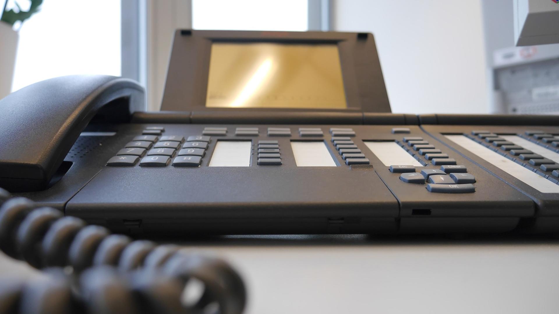Ein Telefon steht auf einem Schreibtisch in einem Sekretariat.