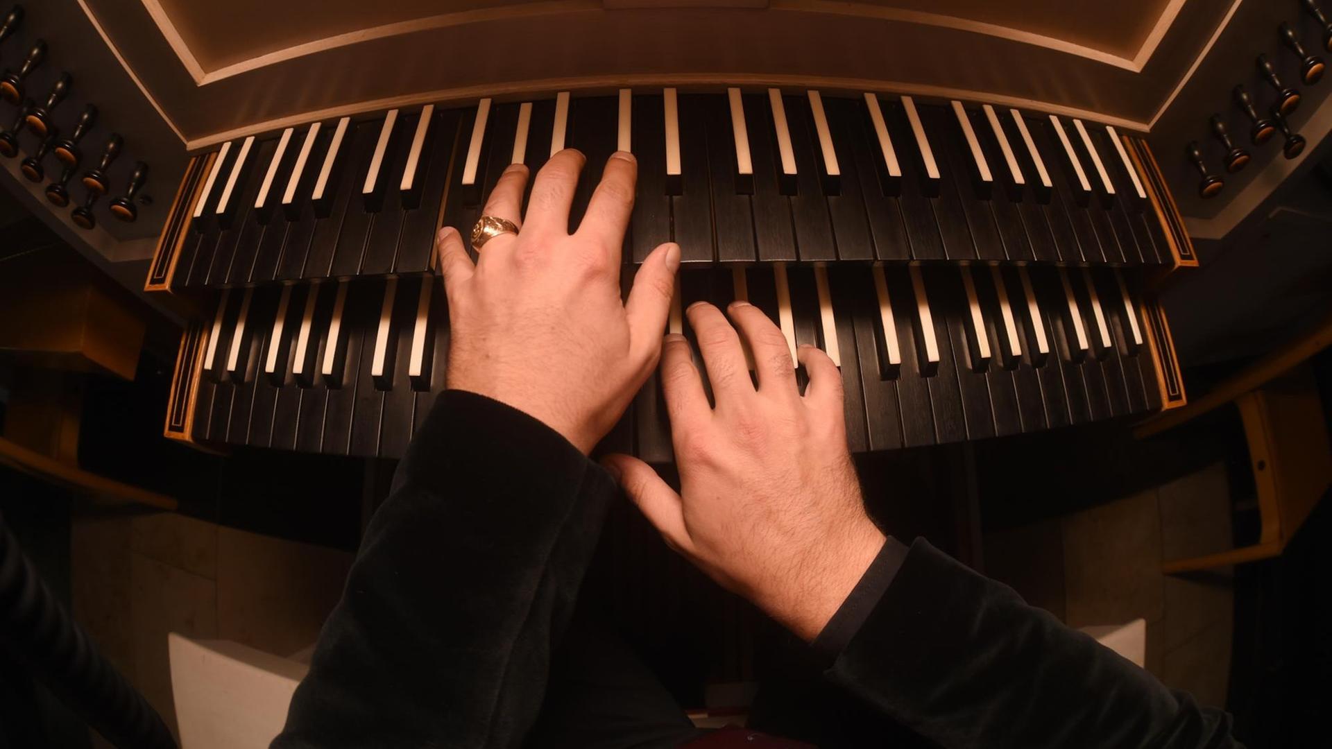 Hände eines Orgelspielers spielen am 12.10.2015 in München-Neuaubing (Bayern) in der Kirche St.Konrad die Tasten einer Orgel.