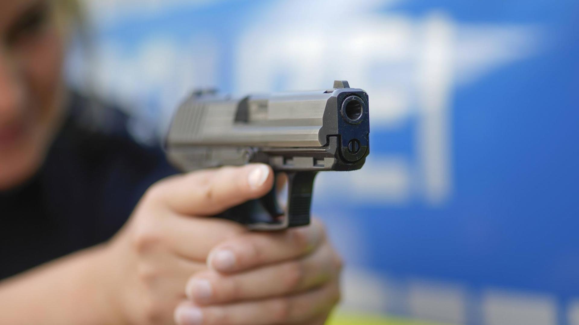 Eine Polizeibeamtin zielt mit einer Pistole (Symbolbild)