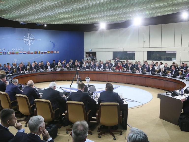 Die Teilnehmer des Außenminister-Treffens der NATO-Länder sitzen im NATO-Hauptquartier in Brüssel zusammen.