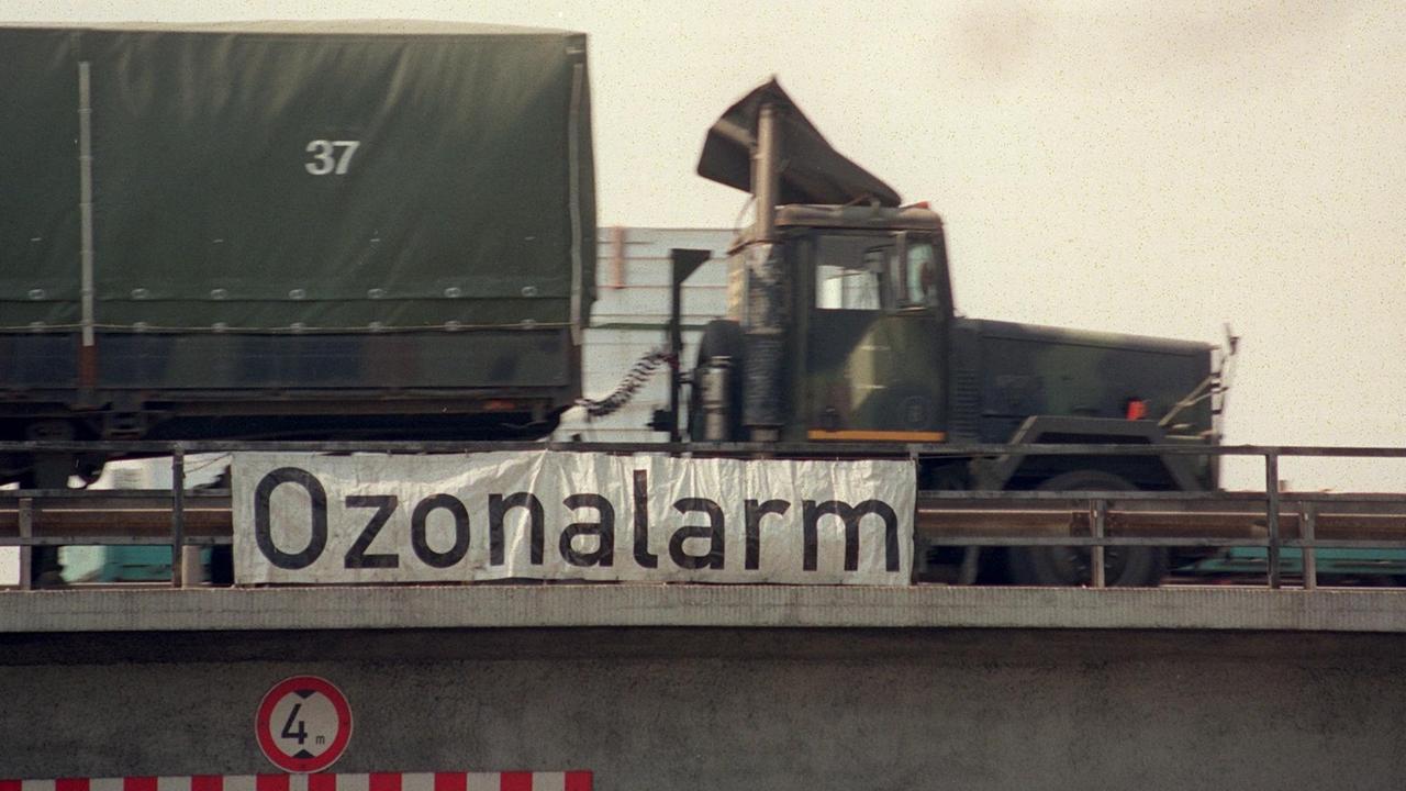 Ein Lastwagen fährt an einem Transparent mit der Aufschrift "Ozonalarm" vorbei