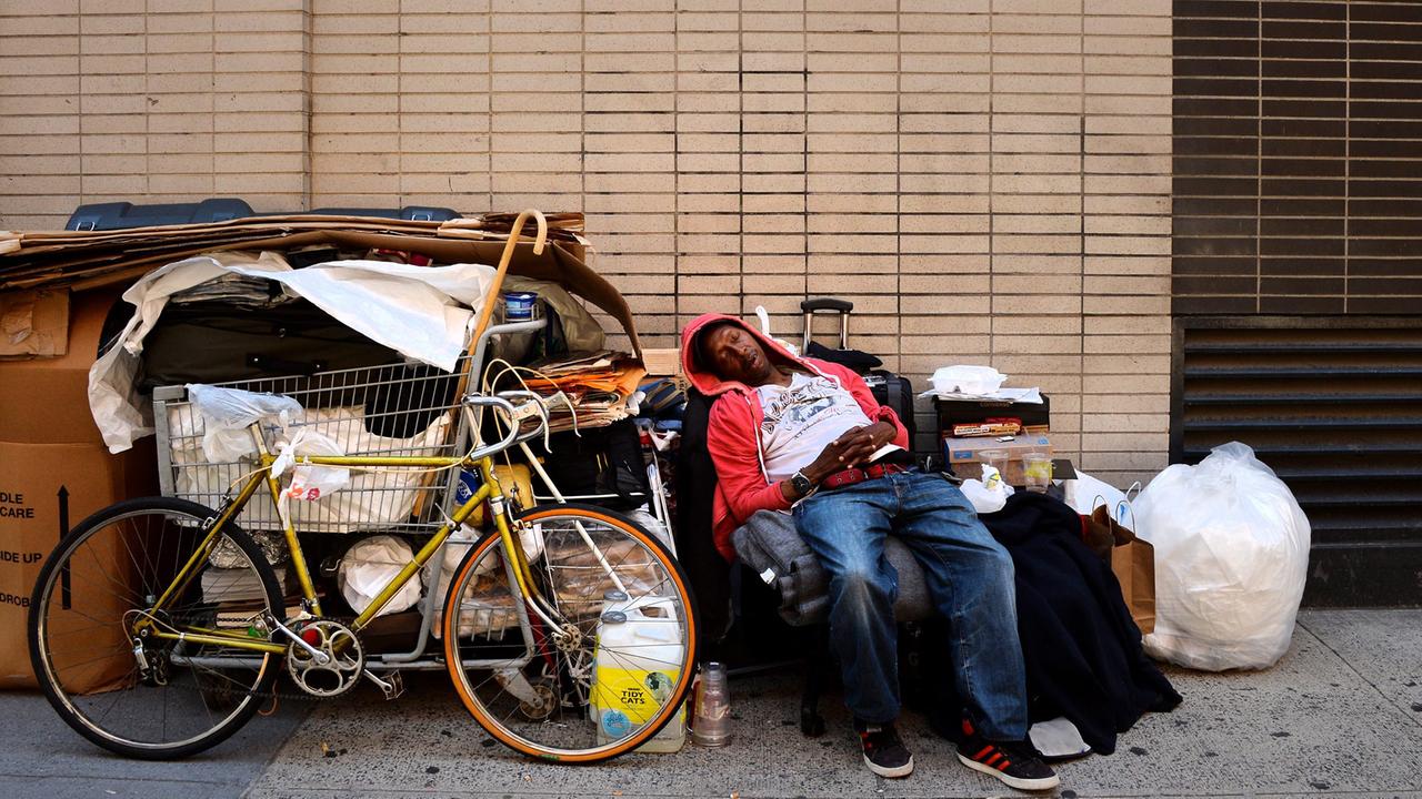 Ein Mann schläft in einer Straße in New York.