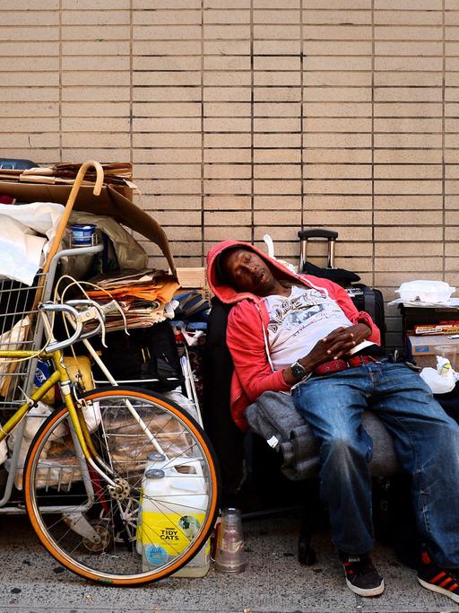 Ein Mann schläft in einer Straße in New York.