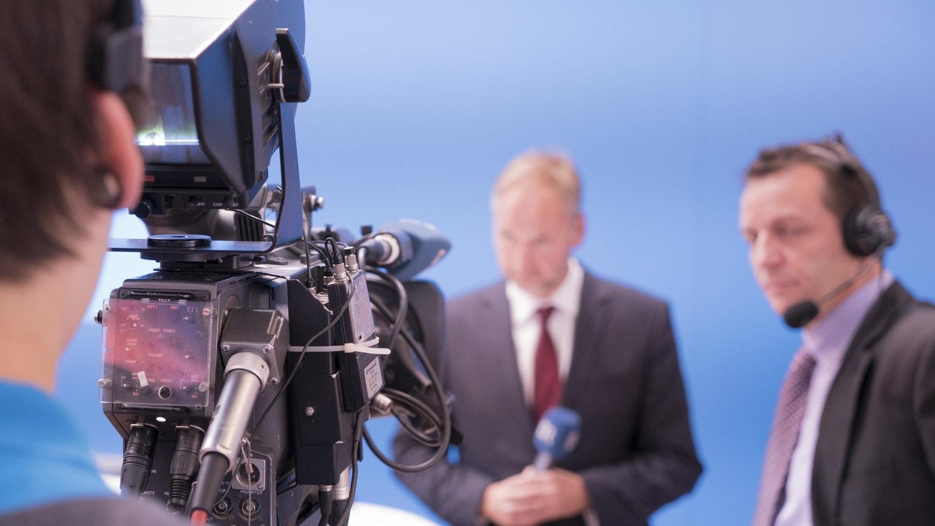 Ein Kameramann filmt einen Mann mit Mikrofon