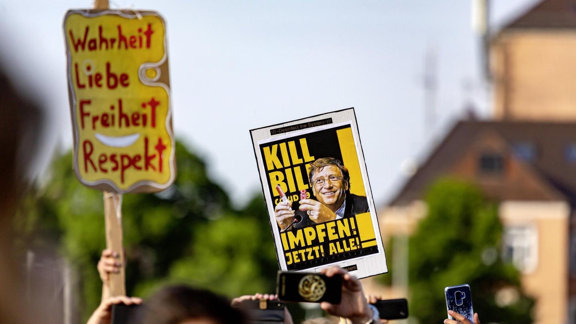 Demoplakate mit den Aufschriften „Wahrheit, Liebe, Freiheit, Respekt“ und „Kill Bill – COVID 19 – Impfen! Jetzt! Alle!"