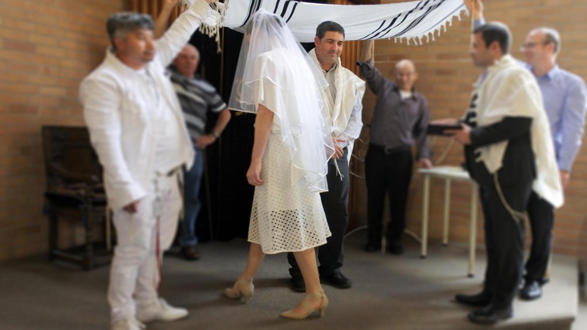 Bild zeigt den Moment, in dem bei die Braut bei einer jüdischen Hochzeit ihren Ehemann sieben Mal umkreist
