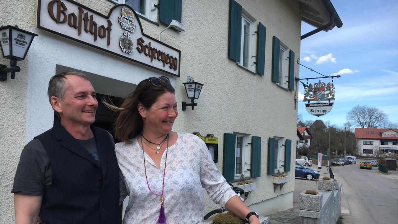 Cathy Tallman und Andreas Pröls stehen in Unering in der Nähe von München vor dem Gasthof Schreyegg. Sie wollen das Dorfwirtshaus neu beleben. 