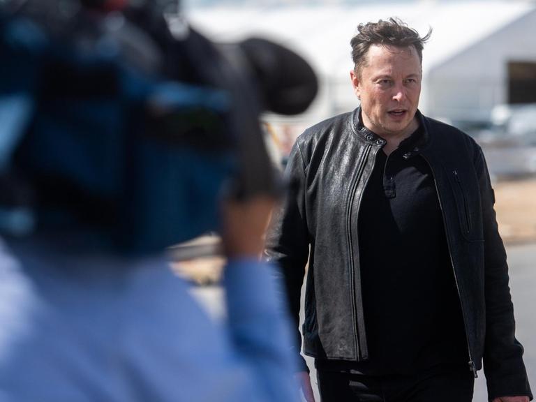 Tesla-Chef Elon Musk steht am 17. Mai auf der Baustelle der Tesla-Fabrik und unterhält sich mit Besuchern.