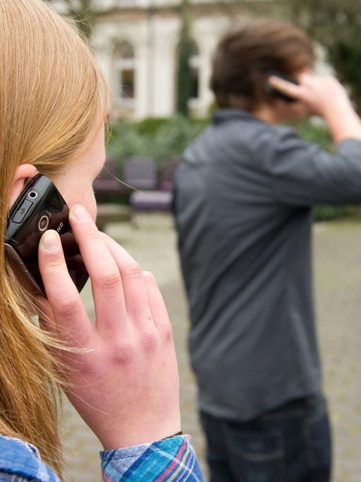 Zehntklässler telefonieren am 22.04.2013 auf einem Schulhof in Braunschweig (Niedersachsen), nachdem sie für eine Woche freiwillig auf ihr Handy verzichtet hatten.