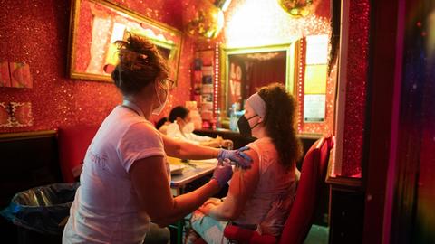 Eine junge Frau lässt sich im Rahmen der Aktion «Kiez-Piks» in der Bar «Wunderbar» nahe der Reeperbahn im Stadtteil St. Pauli gegen das Coronavirus impfen. Nach erfolgter Impfung erhalten die Impflinge einen Pizza-Gutschein.