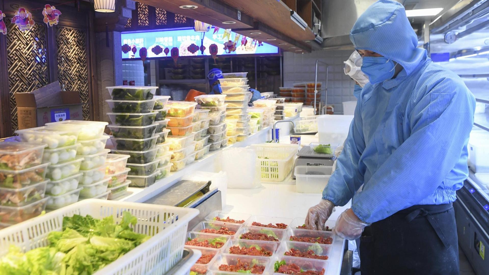 Restaurantmitarbeiter in China bereitet Essens-Lieferung vor. Restaurantmitarbeiter in China bereitet Essens-Lieferung vor.