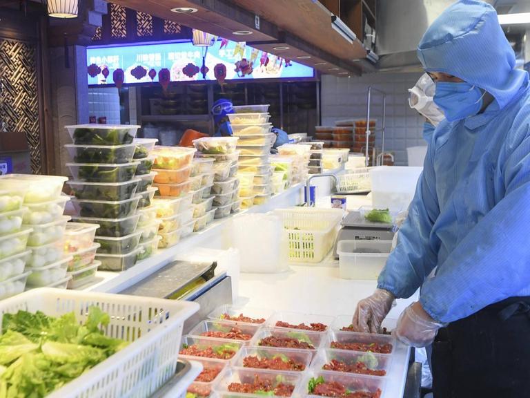 Restaurantmitarbeiter in China bereitet Essens-Lieferung vor.