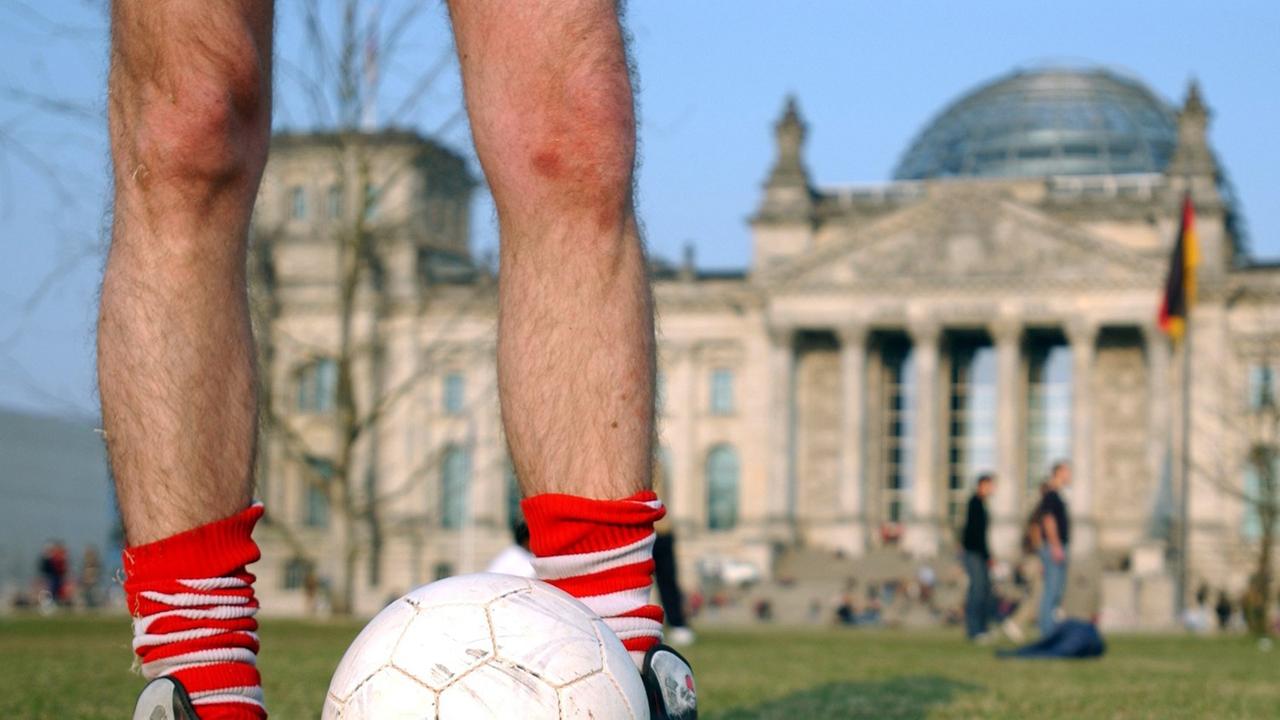 Fußballspieler auf der günen Wiese vor dem Deutschen Reichstag in Berlin Fußballspieler auf der günen Wiese vor dem Deutschen Reichstag in Berlin