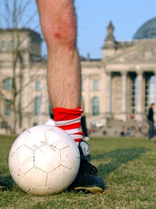 Fußballspieler auf der günen Wiese vor dem Deutschen Reichstag in Berlin