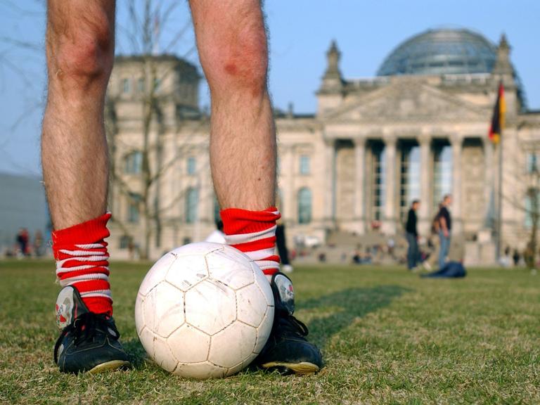 Fußballspieler auf der günen Wiese vor dem Deutschen Reichstag in Berlin