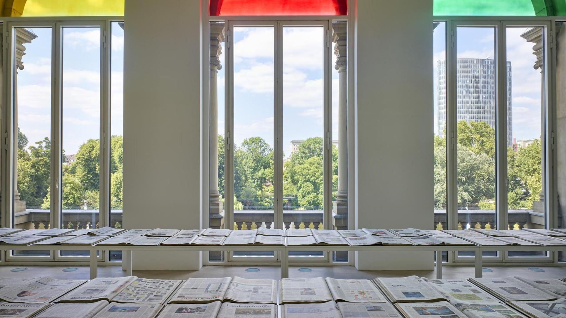Blick über die Ausstellung durch drei Fenster nach draußen