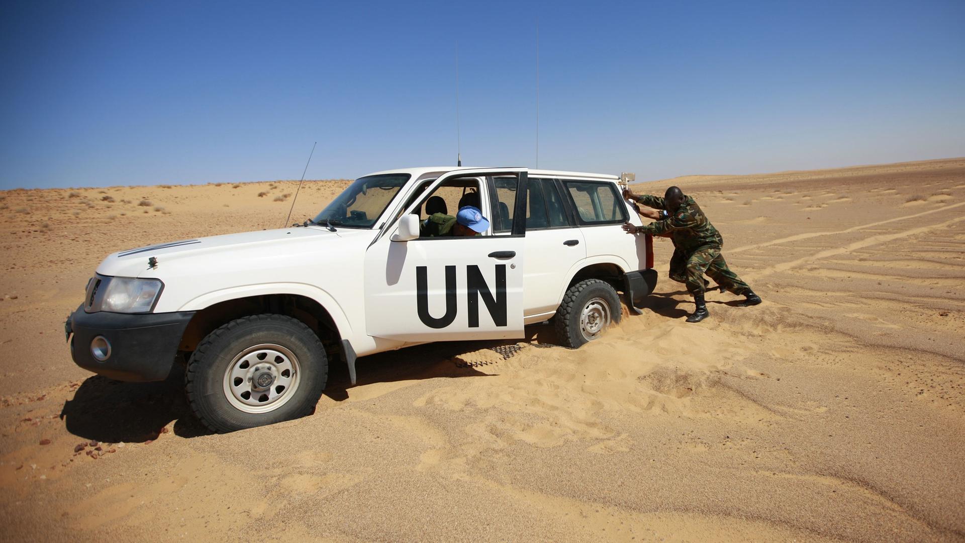 Mitglieder des Military Liaison Office of the UN Mission for the Referendum in Western Sahara (MINURSO), versuchen in Oum Dreyga (Westsahara), ihr Auto aus dem Sand zu bewegen.