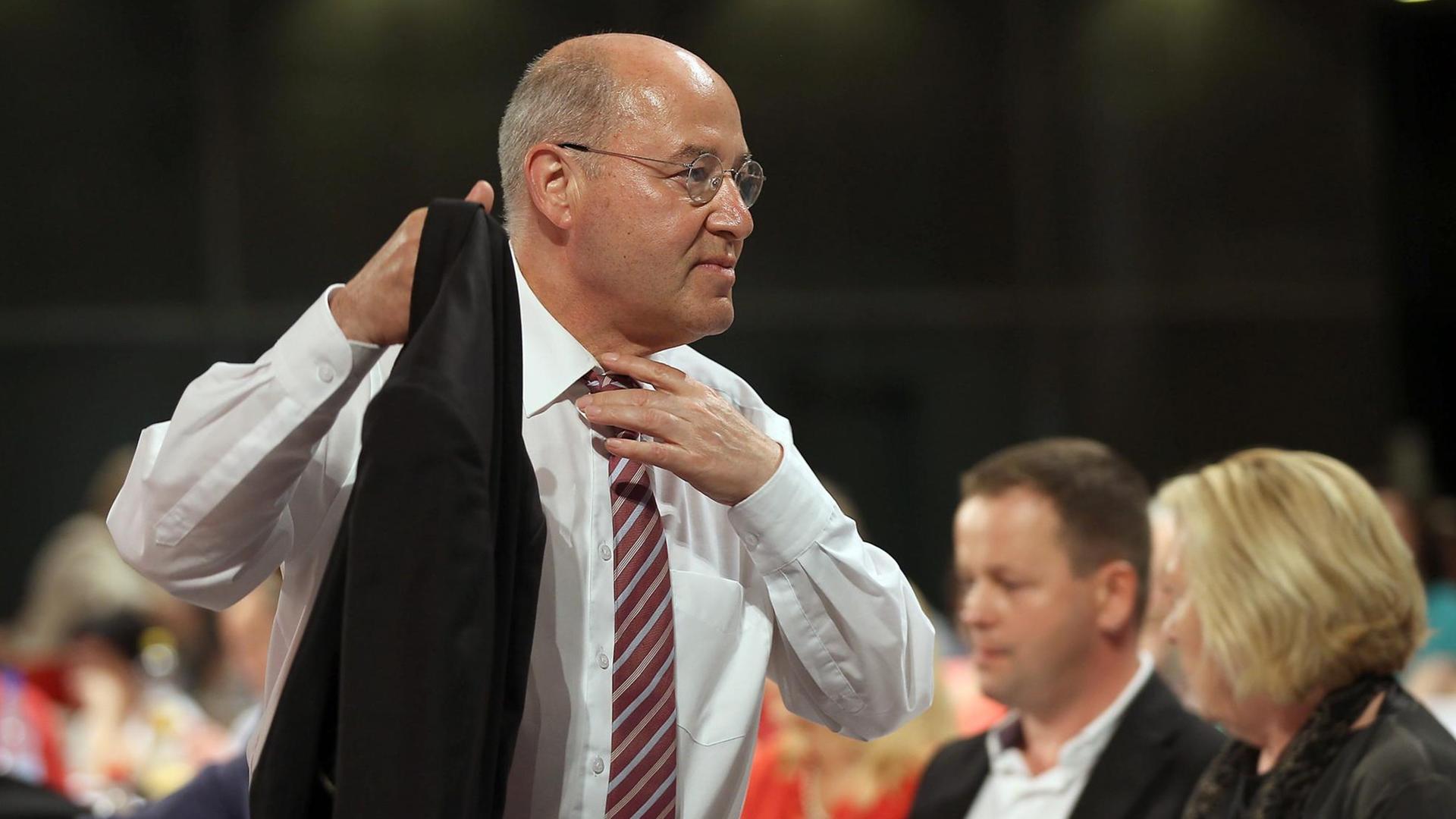 Gregor Gysi nimmt seine Jacke, rückt sich die Krawatte zurecht und geht