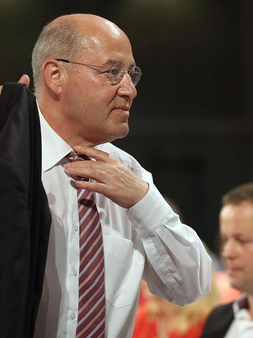 Gregor Gysi nimmt seine Jacke, rückt sich die Krawatte zurecht und geht