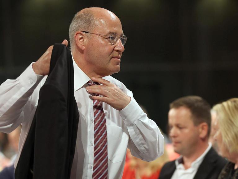 Gregor Gysi nimmt seine Jacke, rückt sich die Krawatte zurecht und geht