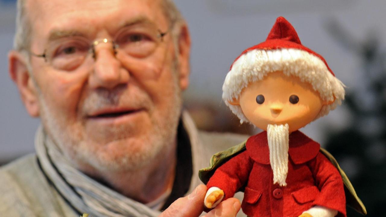 Winfried Kujas hält eine Sandmännchen-Puppe in den Händen.