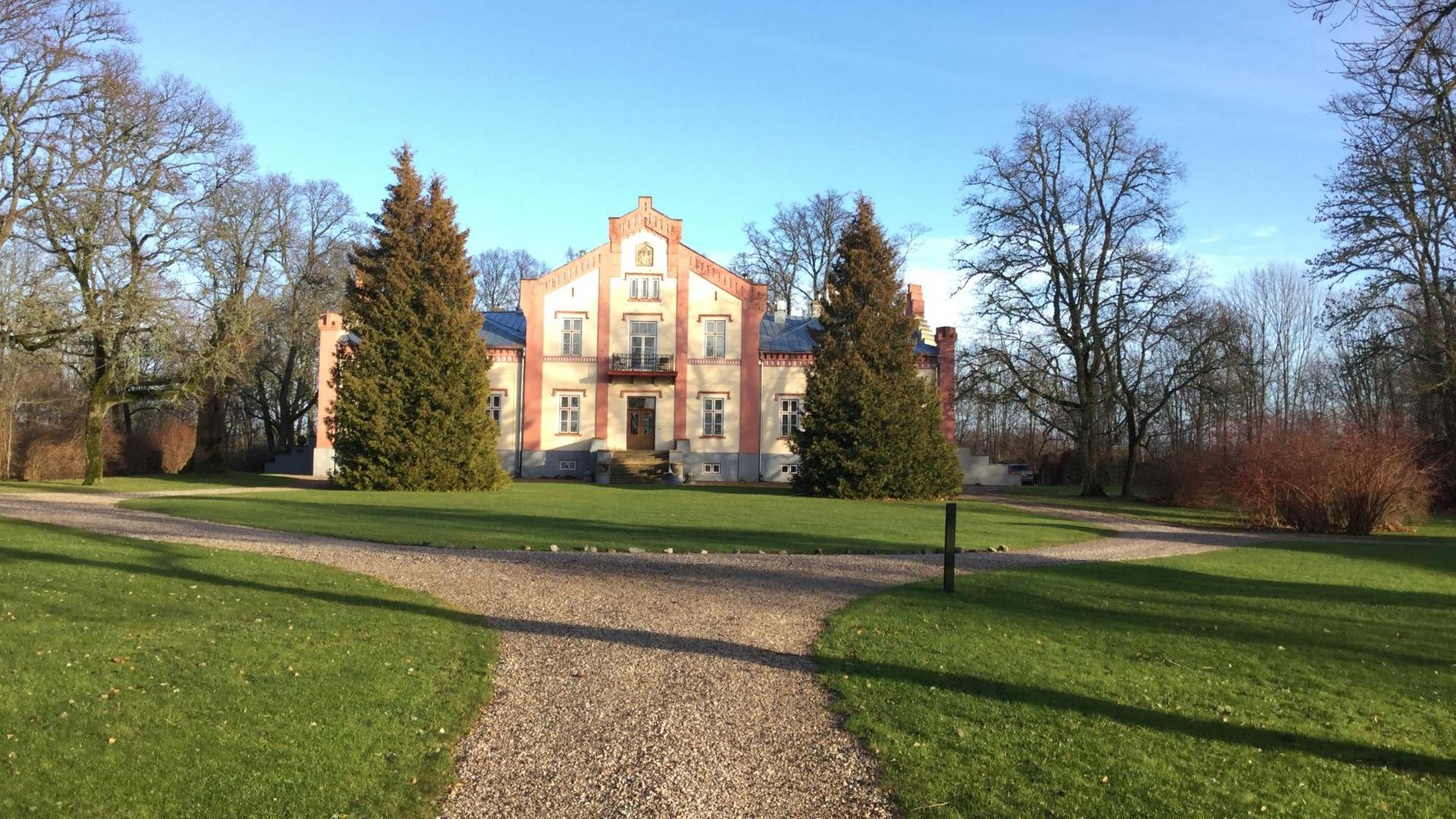 Herrschaftliches Haus im Park, ein breiter Weg, der darauf zuläuft.