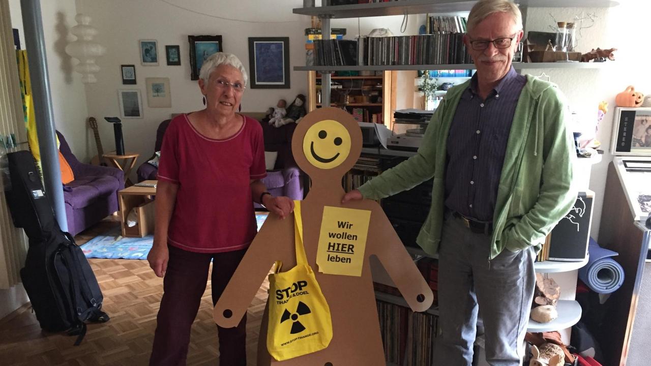 Robert Borsch-Laaks und seine Frau Monika stehen neben eine Papp-Figur in ihrem Wohnzimmer in Aachen-Mitte.
