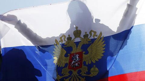Eine Ukrainerin hält bei dem Referendum eine russische Fahne hoch.