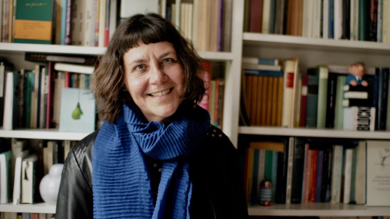 Porträt der Kinderbuchautorin Susanne Rebscher vor einer Bücherwand