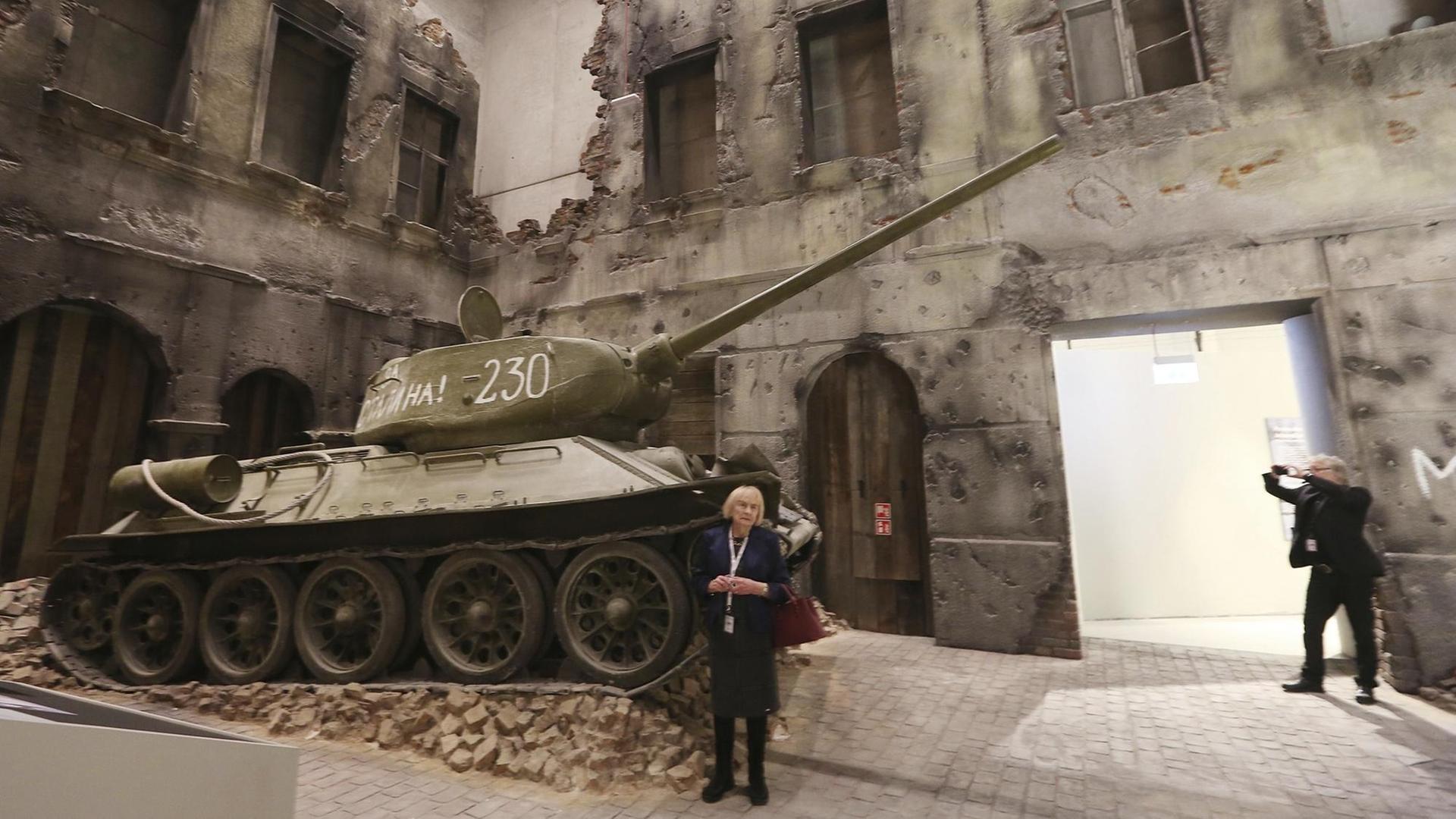 Ein Besucher schaut sich in der Ausstellung einen Panzer an.