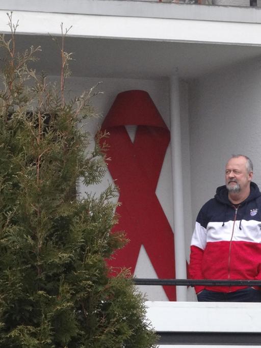 Weit sichtbares Zeichen der Solidarität in Schwerte. Auf dem Balkon seiner Wohnung hat Uwe Görke-Gott die Aids-Schleife angebracht.