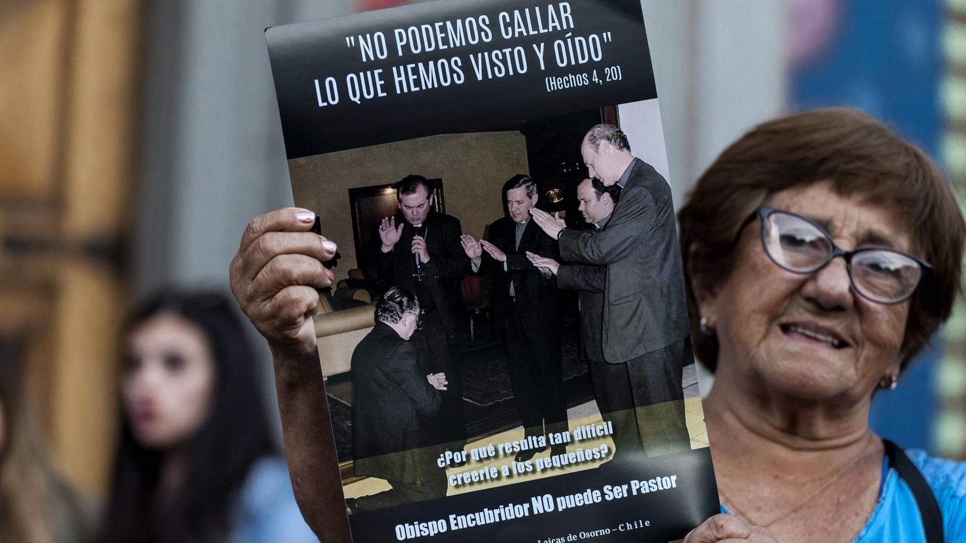 Eine Frau auf einer Demonstration am 24. Februar 2018 gegen den chilenischen Priesterausbilder Fernando Karadima. Auf dem Poster ist Karadima (l) zu sehen, als er von anderen Bischöfen (darunter auch Juan Barros, 3.v.r.) gesegnet wird. Darüber steht ein Vers aus aus der Apostelgeschichte: "Wir können unmöglich schweigen über das, was wir gesehen und gehört haben"