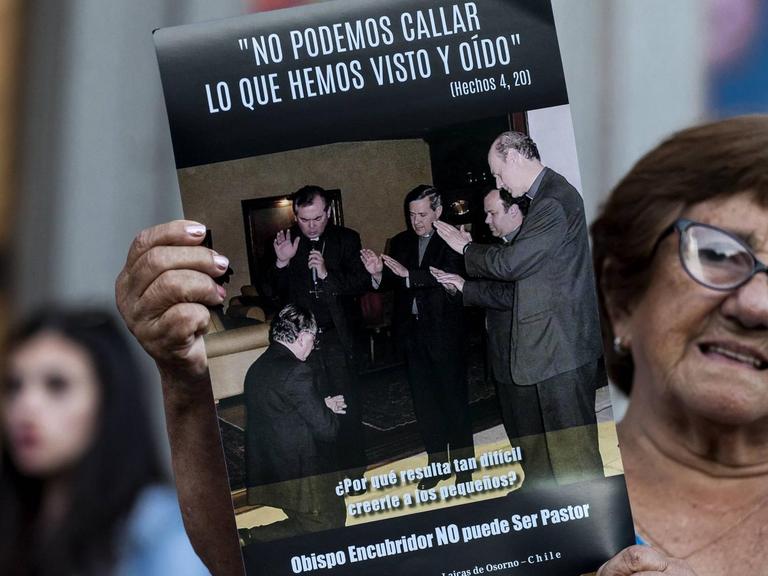 Eine Frau auf einer Demonstration am 24. Februar 2018 gegen den chilenischen Priesterausbilder Fernando Karadima. Auf dem Poster ist Karadima (l) zu sehen, als er von anderen Bischöfen (darunter auch Juan Barros, 3.v.r.) gesegnet wird. Darüber steht ein Vers aus aus der Apostelgeschichte: "Wir können unmöglich schweigen über das, was wir gesehen und gehört haben"