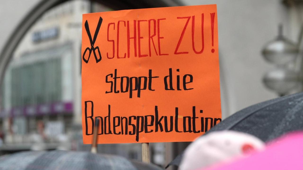 Demonstration und Kundgebung am Karlsplatz Stachus in München anlässlich der Mietpreis Explosion in der Stadt: Plakate und Transparente mit Schriftzug Schere zu. Stoppt die Bodenspekulation.