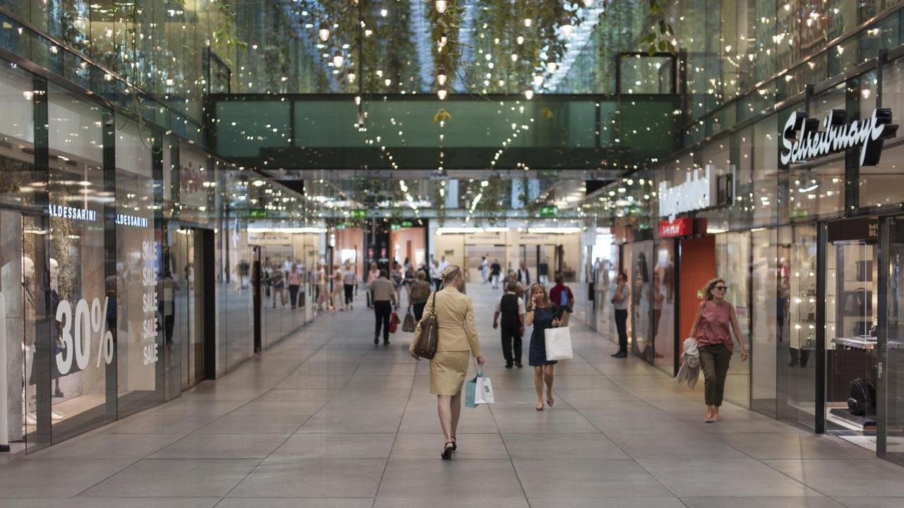Frau geht durch ein Luxus-Shoppingcenter in München