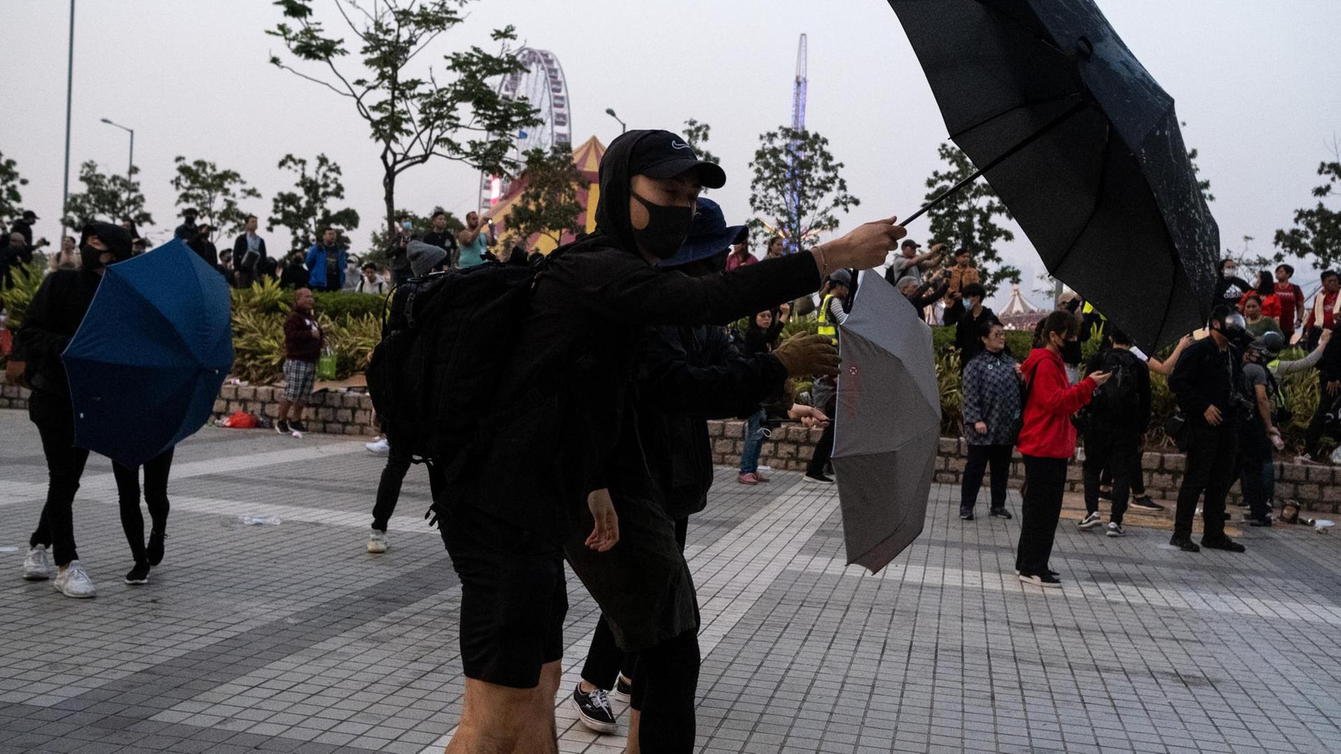 Protestler demonstrieren mit Regenschirmen in Hongkong.