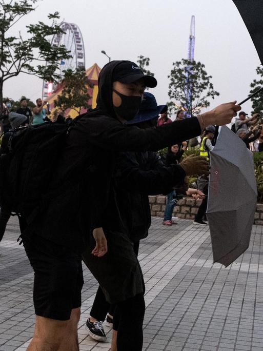 Protestler demonstrieren mit Regenschirmen in Hongkong.