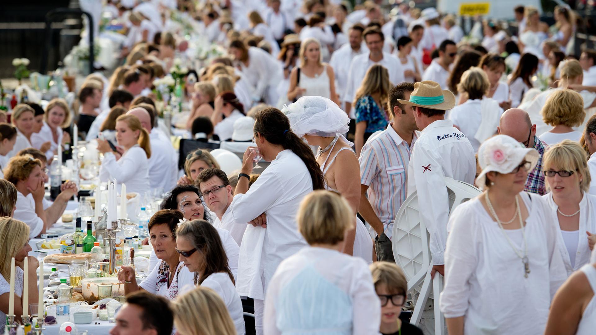 Zahlreiche Menschen speisen am 17.08.2013 beim "Weißen Dinner" in Hamburg ganz in weiß gekleidet rund um das Hafenbecken an der Ericusspitze.