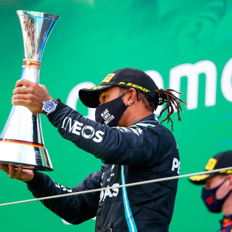 Formel-1-Pilot Lewis Hamilton hält den Siegerpokal hoch.