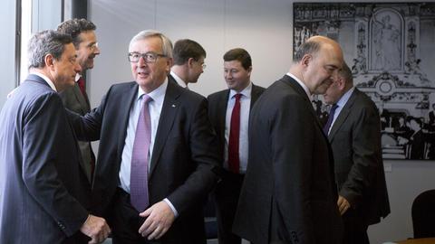 EZB-Präsident Mario Draghi (links) spricht bei einem Treffen in Brüssel mit EU-Kommissionschef Jean-Claude Juncker, rechts im Bild ist der EU-Kommissar für Finanzen, Pierre Moscovici zu sehen.