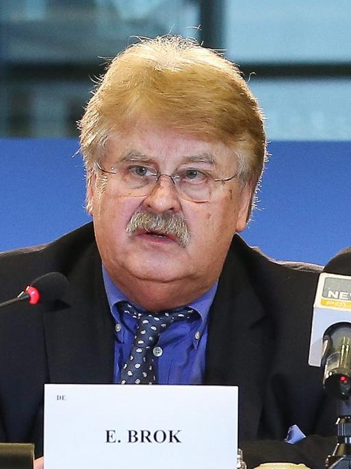 Elmar Brok sitzt an einem Tisch und spricht in ein Mikrofon
