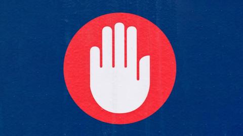 Ein Piktogram einer Hand vor einem roten Kreis, auf blauem Hintergrund.