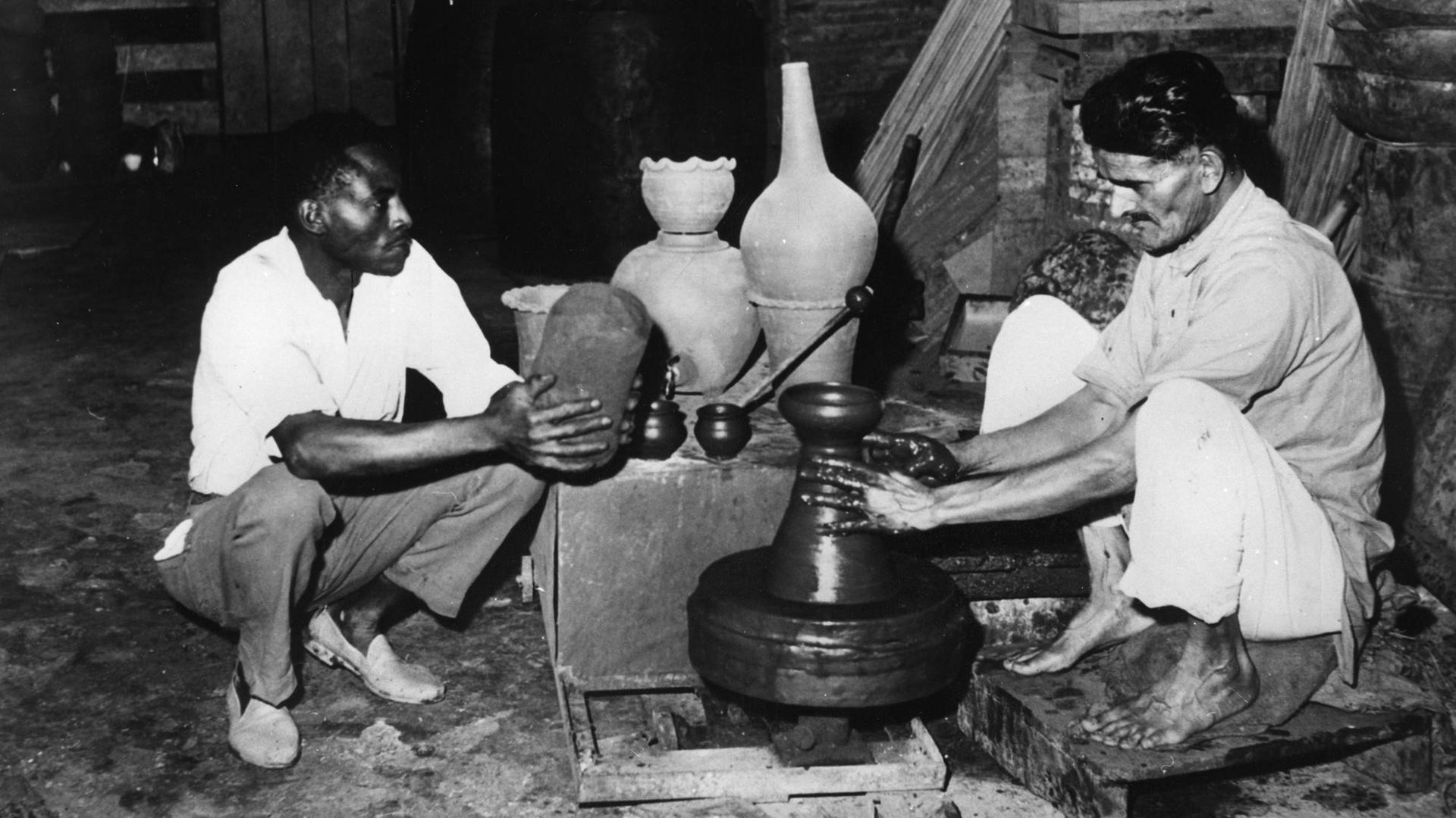 Copyright: imago/United Archives International An Asian pottery maker finishes off one of is last pots watched by his African helper. With most his clients gone he plans to join the the mass exodus of Kenyan Asians who are travelling to Britain to beat the British Government s proposed restrictions on immigration, the clampdown due to start the following week will only allow 1500 immigrants a year. Nairobi , Kenya 27 February 1968