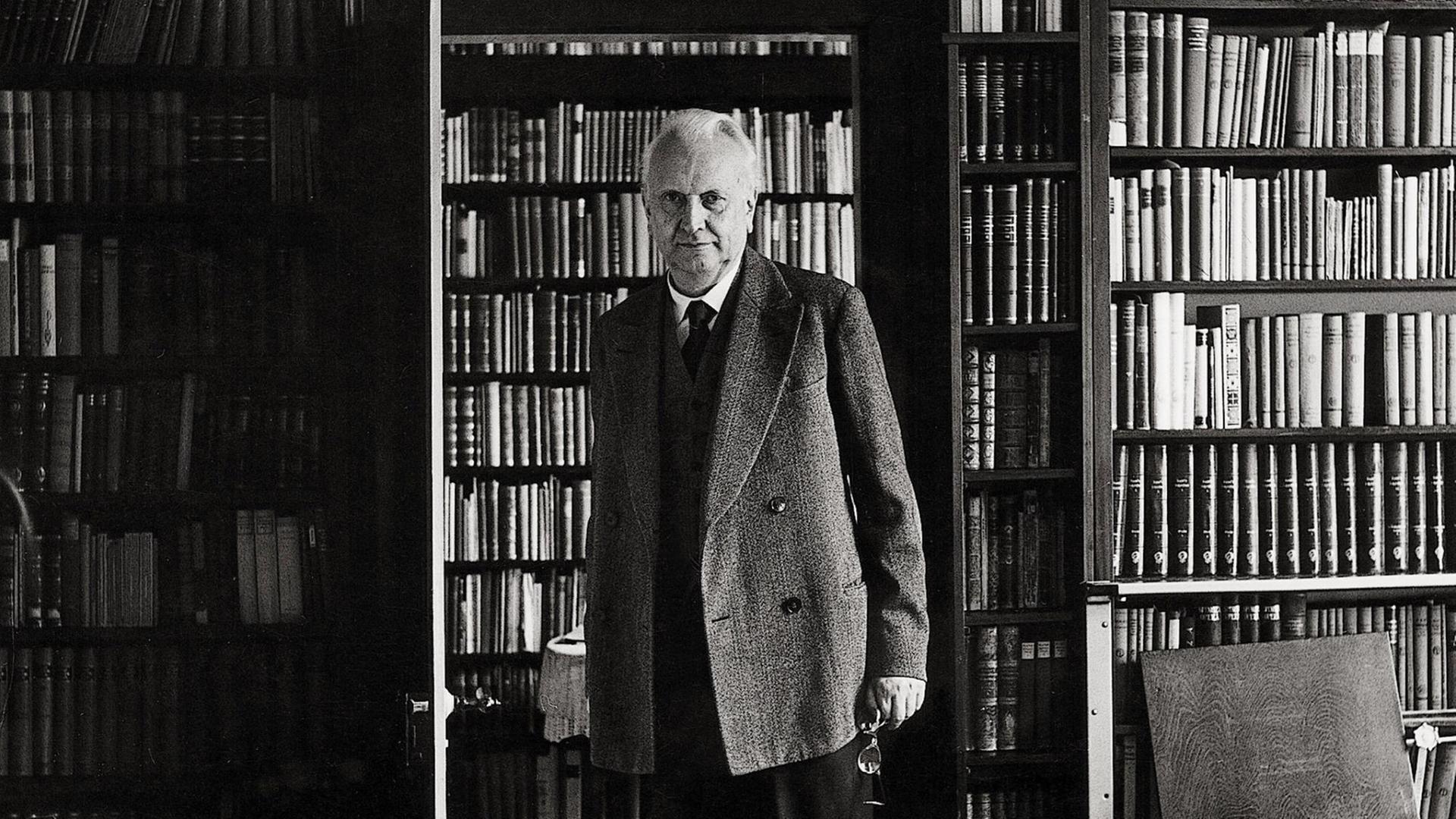 Der Philosoph Karl Jaspers in seinem Haus in Basel vor seiner Bibliothek, 1956.