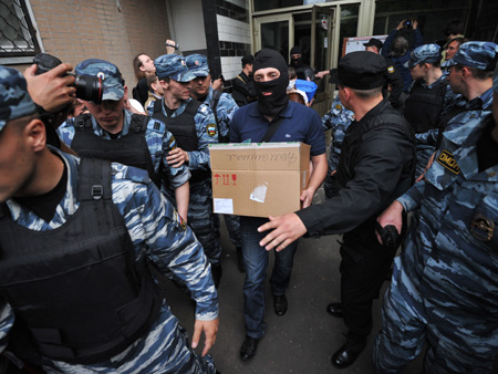 Russische Sicherheitskräfte tragen beschlagnahmtes Material aus der Wohnung eines russischen Oppositionellen in Moskau