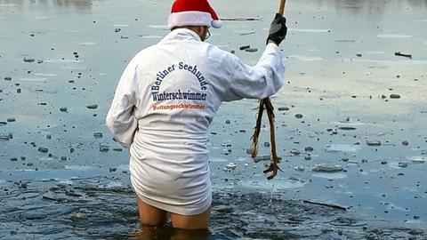 Mario von den "Berliner Seehunden". Winterschwimmer mit Bademantel im eiskalten Wasser.